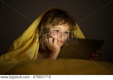Bed Time Story. Kid Playing Game On Tablet In Bed At Night. Kids With Social Media. Child Lying In B