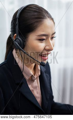 Asian Call Center With Headset And Microphone Working On Her Laptop. Female Operator Provide Excepti