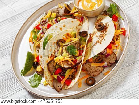 Grilled Steak Tacos With Olives, Tomatoes, Red Onion, Avocado, Cilantro, Corn, Shredded Cheddar Chee