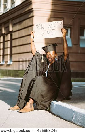 Unemployed Black Guy Sitting With Upraised Cardboard Poster On Street Looking For Job. University Or