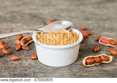 Bowl Of Peanut Butter And Peanuts On Table Background. Top View With Copy Space. Creamy Peanut Pasta