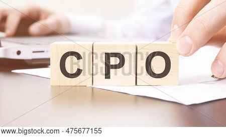Hand Holding Wooden Cube With Cpo Text On Table Background. Financial, Marketing And Business Concep