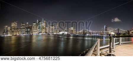 View Of Lower Manhattan At Dusk Seen From Brooklyn. Remaining Of An Old Pier Can Be Seen At The Fore