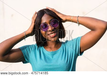 Sunkissed Summer Vibes: Portrait Of A Black Tourist Woman In Green Tee And Sunglasses
