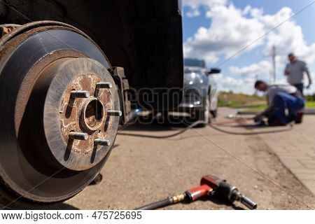 Car On Tire Mounting With Removed Wheel On Pneumatic Jack, Seasonal Tire Change, Car Service Concept