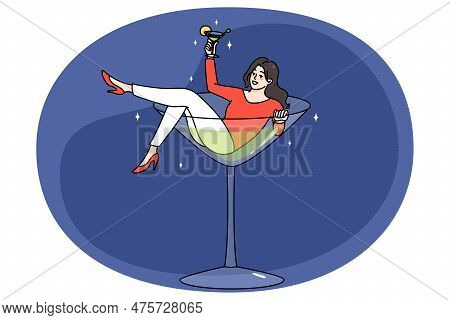 Overjoyed Young Woman Lying In Martini Glass Having Fun Drinking Alcohol. Concept Of Bad Habit Or Ad