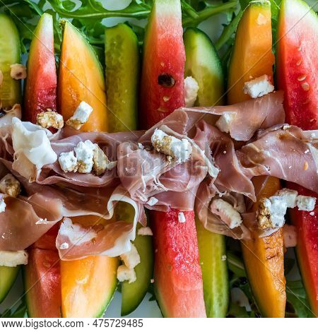 Melon And Cucumber Wedges Garnished With Prosciutto And Feta Cheese.