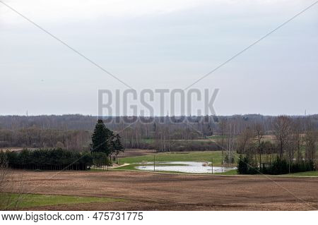 A Field With A Water Feature And A Field In The Background