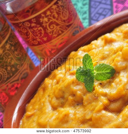 крупным планом глиняная чаша с кормы карри и некоторые жуткие очки с чаем