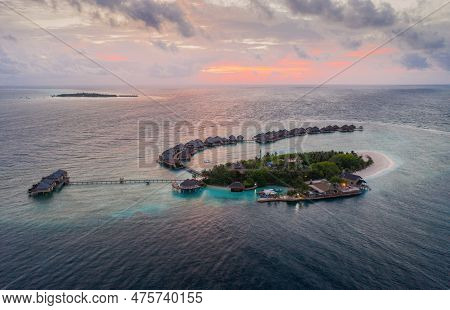 Lonely Tropical Island In Indian Ocean At Sunset, Maldives. Aerial Drone Shot. July 2021.