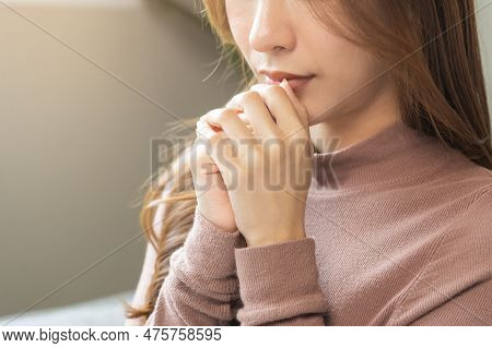 Hopeful Make Wish, Calm Asian Young Woman Belief, Hand In Prayer, Sitting Meditating On Sofa At Home
