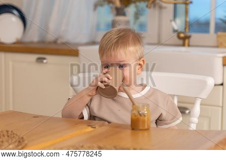 Happy Family At Home. Baby Boy Feeding Himself In Kitchen. Little Boy Drink Water And Eat Healthy Fo