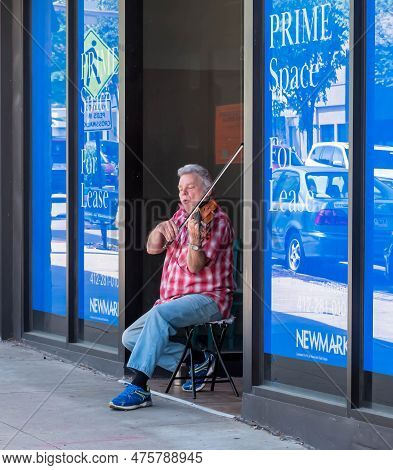 Pittsburgh, Pennsylvania, Usa April 27, 2023 A Man Playing Violin In A Storefront Entranceway On For