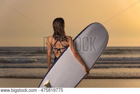 Download High Resolution Photo Of A Surfer Girl. Advertisement For Surfing In Nazare, Portugal.