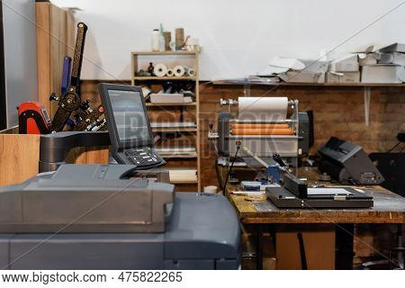 Modern Print Center Equipment Next To Monitor And Paper Trimmer.
