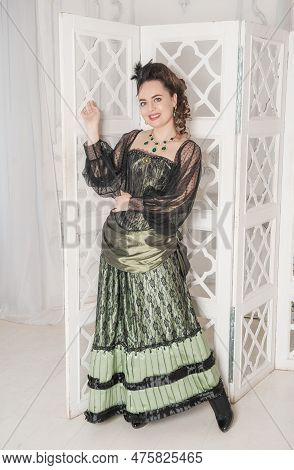Beautiful Young Smiling Woman Wearing Green Medieval Vintage Victorian Style Dress Stand Near Screen