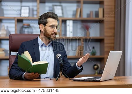 A Young Man Pastor Of A Church, Community Sits In The Office With A Laptop And A Microphone And Read