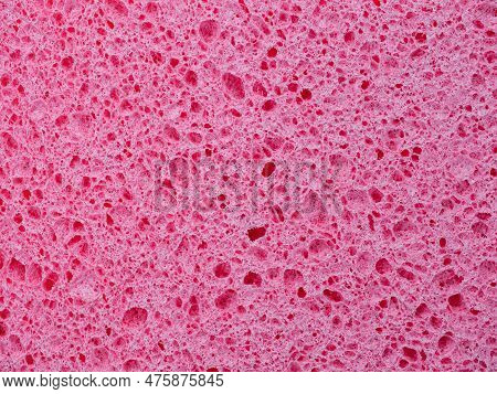 Close-up texture of a washing sponge. Pink abstract background