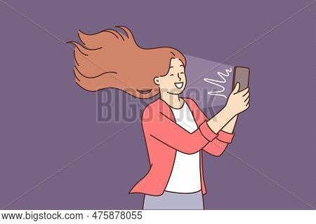 Happy Woman Takes Selfie On Mobile Phone Camera And Smiles Standing With Hair Blowing In Wind. Posit