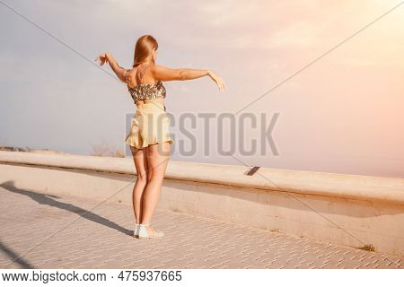 Woman Summer Dance. Silhouette Of A Happy Woman Who Dances, Spins And Raises Her Hands To The Sky. A