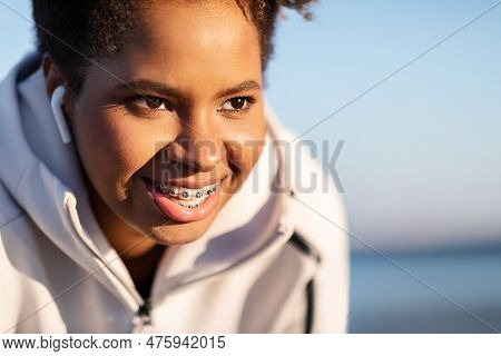 Closeup Portrait Of Smiling Young Black Female Athlete Resting Outdoors After Training