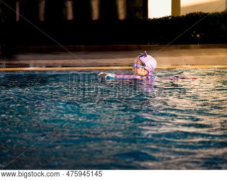 Asian Child Or Kid Girl Wearing Swimming Suit To Learning On Swimming Pool , Learn And Training Swim