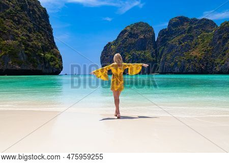 Beautiful Young Blonde Woman In Orange Dress On A Maya Bay Beach During Excursion Of Phi Phi Leh Isl