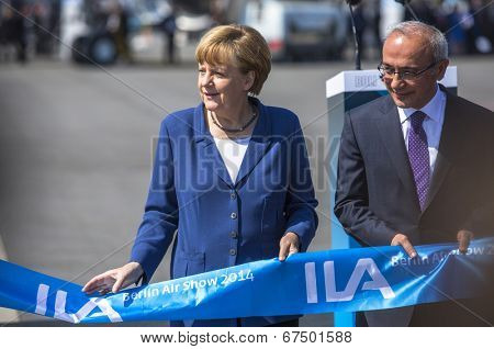 BERLIN, GERMANY - MAY 20, 2014: German Chancellor Angela Merkel (L) and Turkish Minister of transport Lutfi Elvan (R) open up the International aviation and space exhibition ILA.