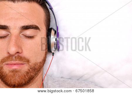 Man with headphones in bed