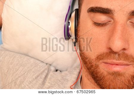 Man with headphones in bed