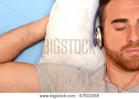 Man with headphones in bed