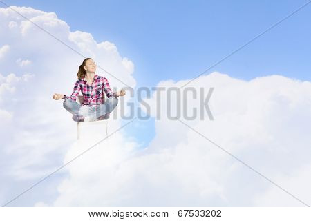Young woman sitting on chair and meditating