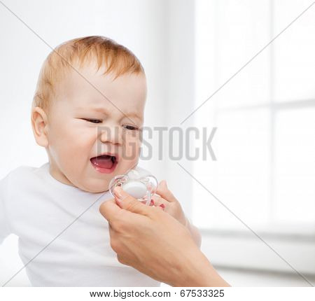 child and toddle concept - crying baby with dummy
