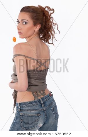 Sexy dziewczyna z frajerem w niebieskie dżinsy z tatuaż.