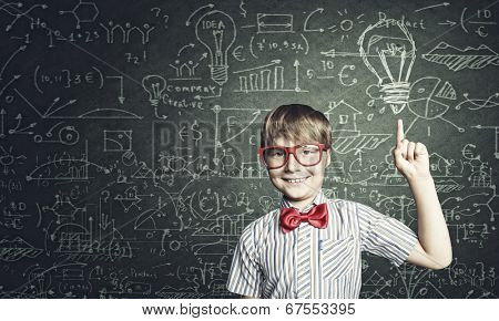 Genius boy in red glasses near blackboard with formulas