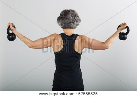 Middle Aged Female Sports Trainer With Kettle Bells