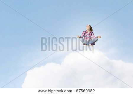 Young woman sitting on chair and meditating