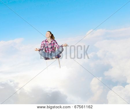 Young woman sitting on chair and meditating