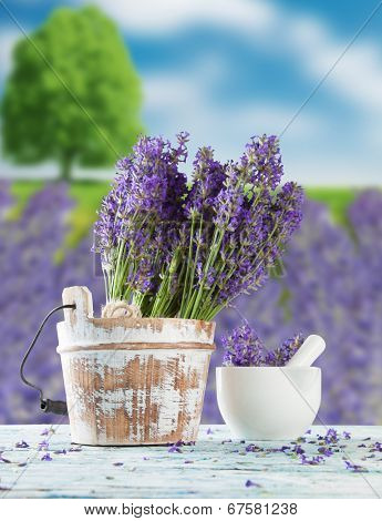 Harvested lavender flowers on wooden planks, blur field on background
