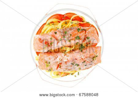 fresh fried natural pink salmon on italian traditional tagliatelle backed with tomato and vegetables isolated over white background
