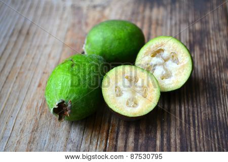 Green feijoa fruit on wooden table
