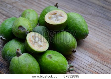 Green feijoa fruit on wooden table