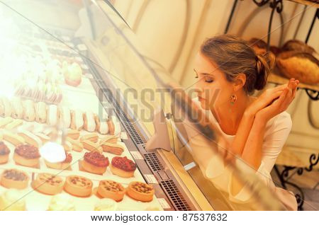 Woman Choosing Cakes And Desserts In A Cafe