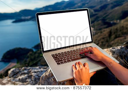 Man with laptop on the top of mountain
