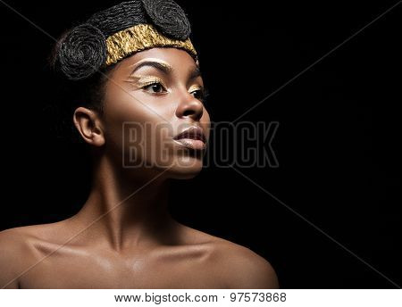 African girl with bright makeup and creative gold accessories on the head. Beauty face.