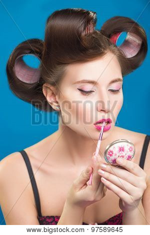 Sexy young pin-up girl doing make-up