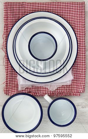 Vintage Enamelware Crockery On Retro Cloths On Rustic Wooden Background