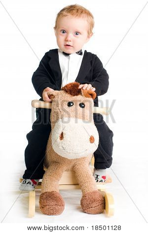 เด็กใน Tailcoat บนม้าโยก