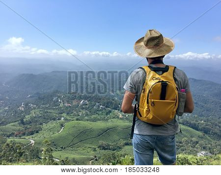 Young caucasian male traveling backpacker up hill and down dale in Munnar Kerala state Idukki district India