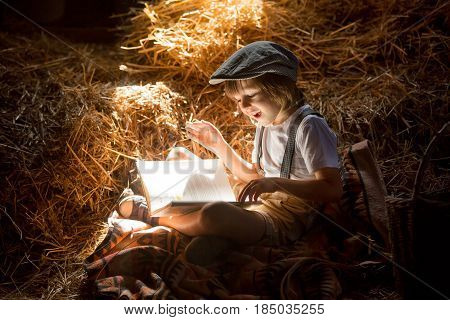 Sweet Child, Boy, Reading A Book On The Attic On A House, Sitting On A Hay Of Straw